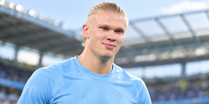 Alt: Football player in a light blue kit at the stadium before a match